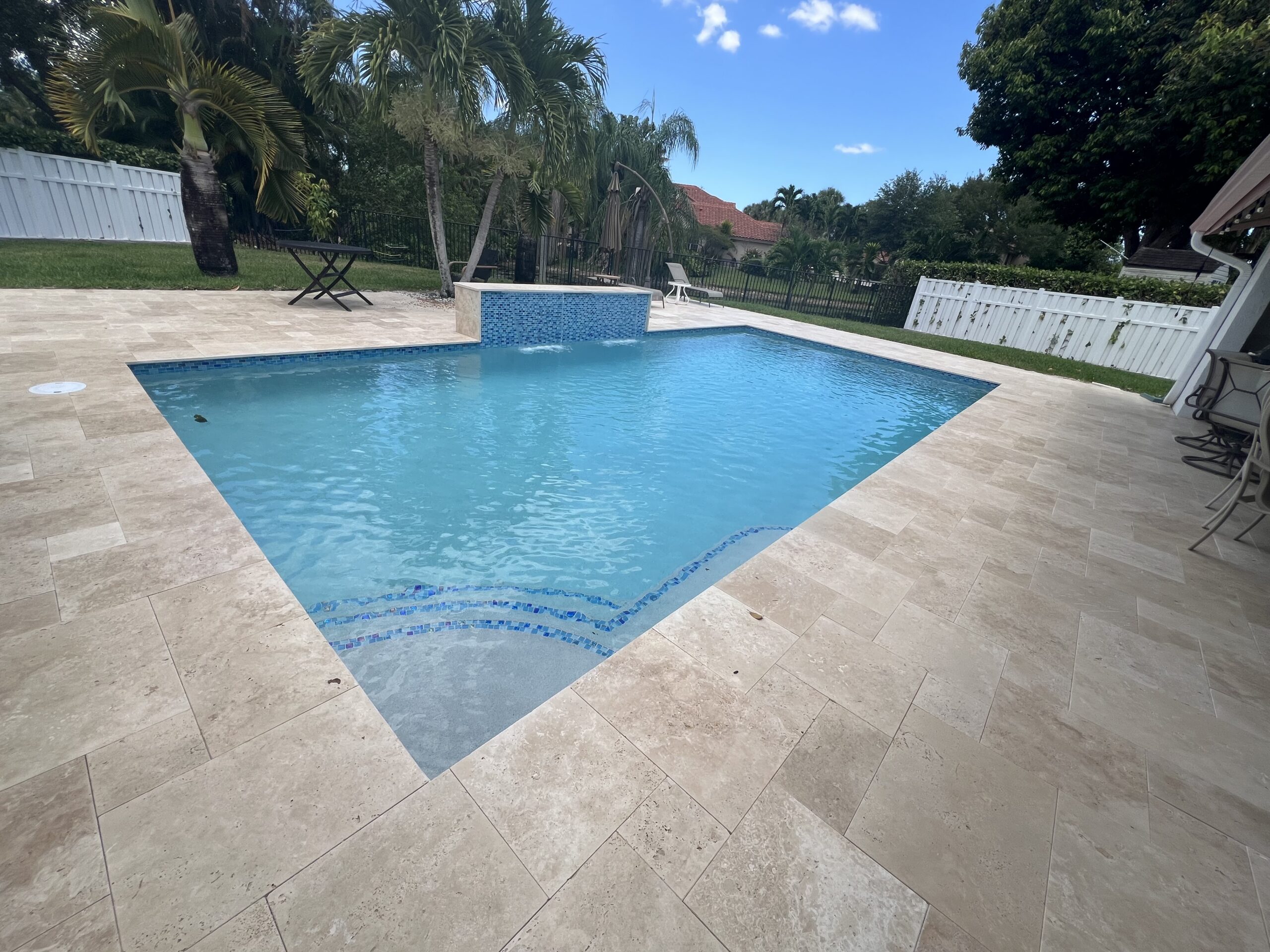 Travertine pool deck paver material for South Florida pool deck renovation